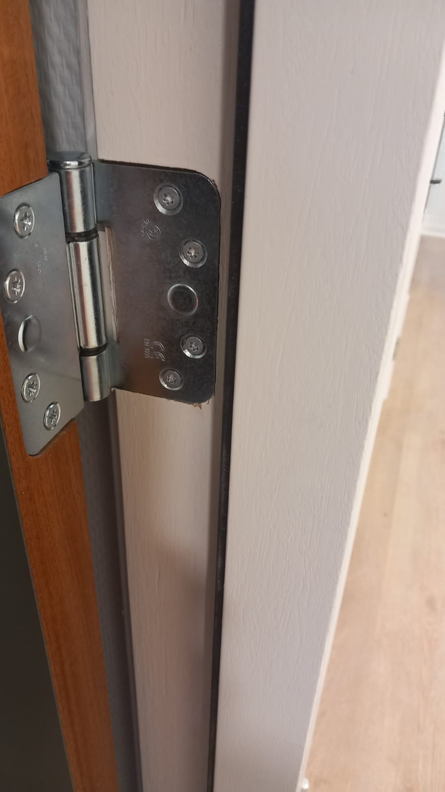 Lange, strak geschilderde gang met houten vloer
